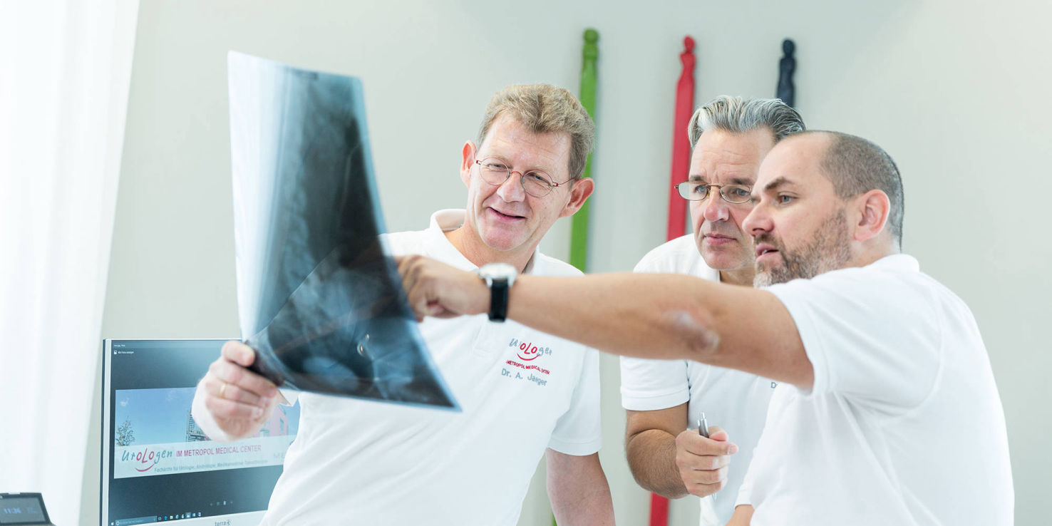 drei Ärzte begutachten ein Röntgenbild